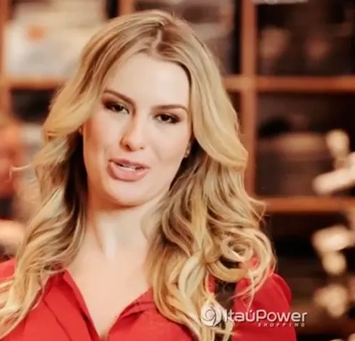 Mulher loira de blusa vermelha falando para a câmera, cena do filme Liquidificação do ItaúPower Shopping